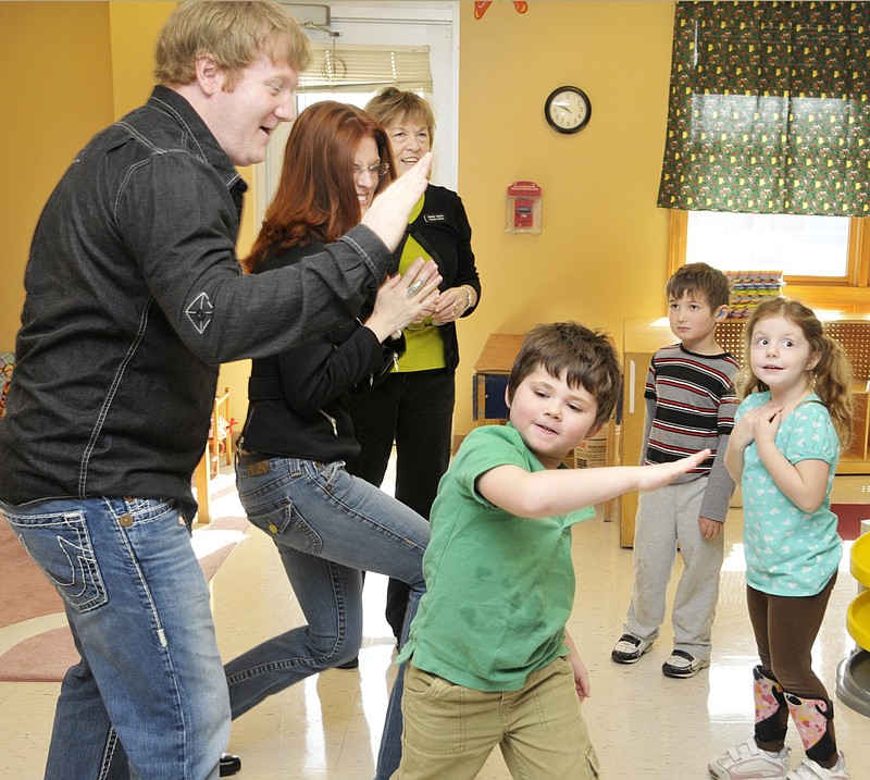 Comedian Jon Reep is glad-handed by Seth Deyarmond during a visit Thursday morning to staff and students at the Special Learning Center, including director Debbie Hamler  (back) and children Courtney Hoelscher and Travis Anderson. Reep, who was accompanied by wife Genta, performed Thursday night at the annual Moments of Magic fundraiser to benefit the center. 