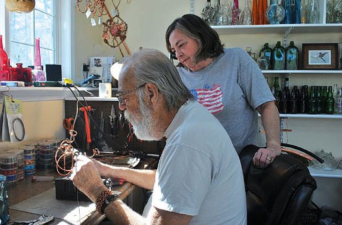 Terrie Merritt looks on as her husband, Bill, twists a copper piece used to create an original wine-bottle hummingbird feeder in the couple's artisan studio Ozarklake Distinct Decor. Bill sits on the board of directors and is a juried artist member of the Best of Missouri Helping Hands, which will sponsor ARTSmart Conference on March 9-11, along with a first Artisan Showcase open to the public March 10 at Inn at the Grand Glaize.
