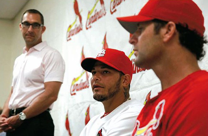 Cardinals catcher Yadier Molina (center) speaks as general manager John Mozeliak and manager Mike Matheny listen during a news conference Thursday in Jupiter, Fla.