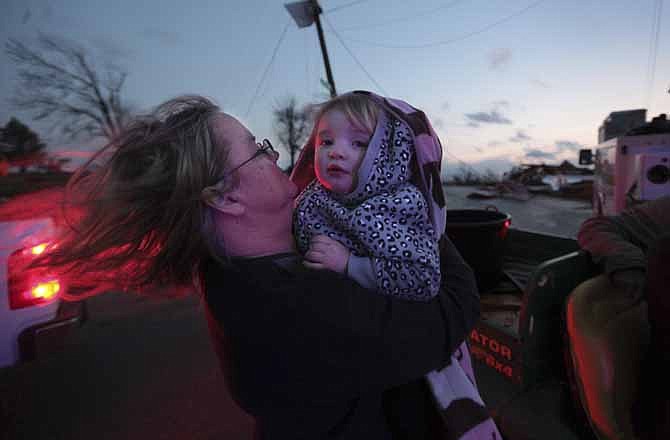 Sandy Ryan, holds her granddaughter, Maci Becraft, in Metro Piner, Ky., after a tornado swept through the area Friday, March, 2, 2012. The front of Becraft's house was destroyed due to the tornado and Ryan is attempting to locate other Becraft family members. Powerful storms stretching from the U.S. Gulf Coast to the Great Lakes in the north wrecked two small towns, killed over two dozen, and bred anxiety across a wide swath of the country on Friday, in the second deadly tornado outbreak this week. (AP Photo/The Cincinnati Enquirer, Carrie Cochran) 