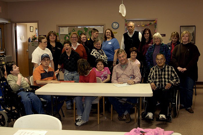 California Mayor Norris Gerhart, surrounded by clients of the Moniteau County SB40 Board, signs a proclamation designating March as National Developmental Disabilities Month. The signing took place Wednesday, Feb. 29, on a visit to the SB40 Board Activities Center at the Industrial Park in the east part of the city. The Executive Director is Lindell Harrison. 