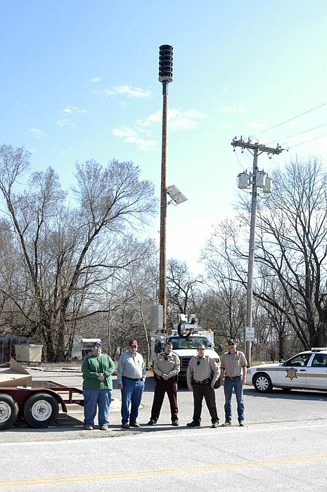 Jamestown's new omnidirectional siren is mounted 50 feet up, with the solar cells about halfway down. At the foot of the pole are Steve Borts and Larry Borts, Jamestown Fire Protection District, Cpl. Wayne Cleveland and Deputy James Corrigan, Moniteau County Sheriff's Department, and Chief Lineman Kevin Oser, Ameren Missouri. 