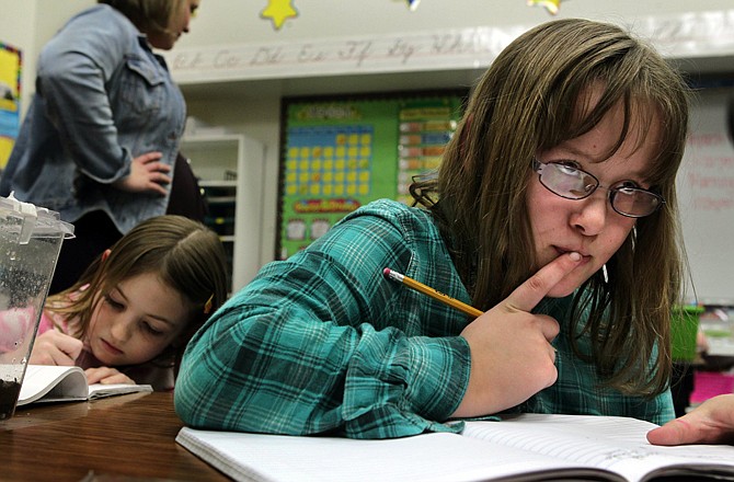 Drina Harring, 8, right, searches for a word while doing a narrative writing exercise beside classmate Solaris Head, 8, in Maureen Stasen's classroom at Sorrento Springs Elementary in Ballwin.