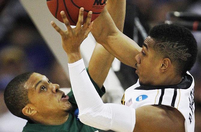 Missouri guard Phil Pressey, right, shoots over Norfolk State guard Pendarvis Williams (11) during the first half of an NCAA college basketball tournament game Friday at CenturyLink Center in Omaha, Neb.
