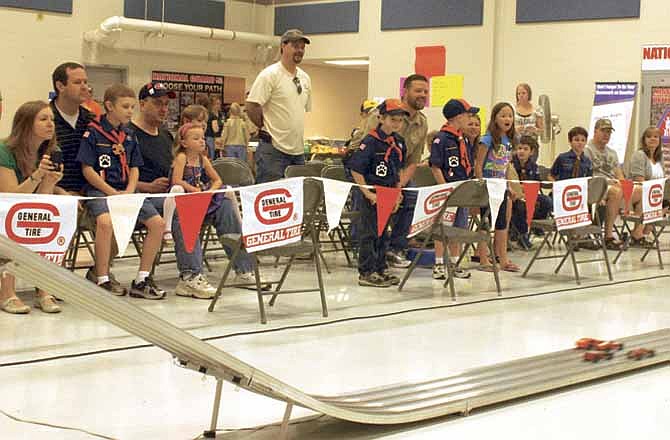 Parents and Cub Scouts from Pack 9 at North Elementary School watch as their cars race down the track Saturday at the Ike Skelton Training Center in Jefferson City for the District Pinewood Derby contest.