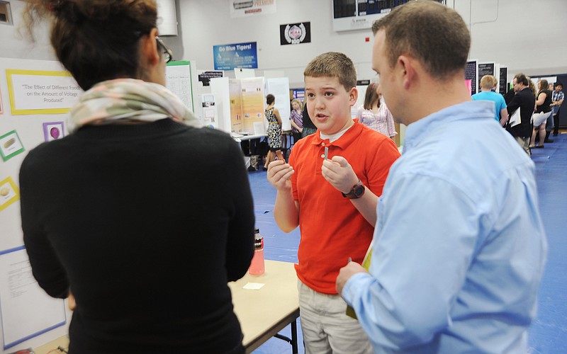 
Sam Wilsdorf, 13, explains his project Friday morning to associate professor Zahra Afrasiabi, left, and professional engineer Ross Kasmann during the 30th annual Lincoln University Regional Science Fair in Jason Gymnasium. Wilsdorf, a seventh-grader at St. Patrick's School in Rolla, measured the voltage of several types of food. "The potato didn't actually do that well," Wilsdorf said of the vegetable which is sometimes seen powering a light bulb. He found a red apple to have the most voltage. A lime, pickle and lemon also produced more voltage than the potato. 