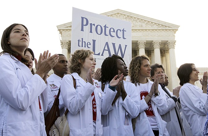 Doctors and medical students supporting the health care reform law signed by President Barack Obama gather in front of the Supreme Court in Washington on Monday.