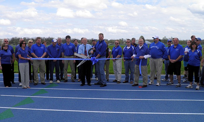 Members of the Jefferson City Chamber of Commerce, Cole R-I School District Board of Education, faculty, staff, students and coaches are present as Superintendent Jerry Hobbs and School Board President Kris Kirchner cut the ribbon at the Russellville Track Grand Opening/Ribbon Cutting Ceremony held Tuesday, March 20.