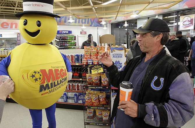 A customer smiles after receiving a free Mega Millions Lottery ticket Friday from the Hoosier Lottery's Mega Millions mascot at a store in Zionsville, Ind. The Mega Millions Lottery jackpot has reached more than $600 million.