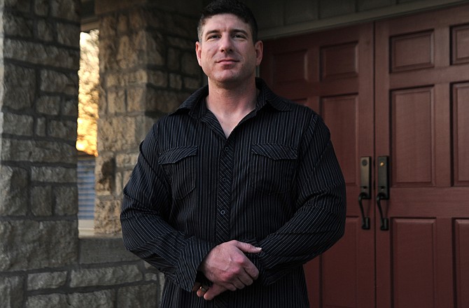 Justin Schnieders stands in front of the building on East Capitol Avenue where, in October 2009, he was accosted by an armed robber.