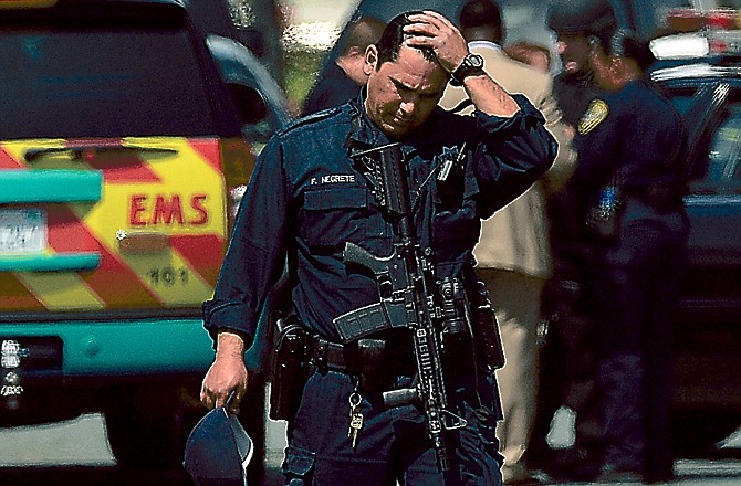 An Oakland police officer pauses outside of Oikos University after seven people were killed in a shooting.