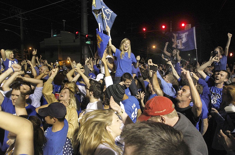 Flags wave as fans celebrate Kentucky's defeat of Kansas Monday in Lexington, Ky. In the ensuing celebrations, a man was shot in the leg. 