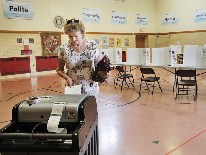 Anne Findlay makes her vote count as she inserts the ballot into the optical reader at Moreau Heights School. Turnout for Tuesday's election was less than 7 percent. 