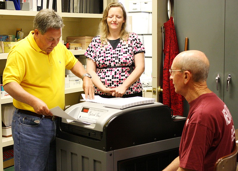 Lee Fritz feeds a ballot into a computer during an official recount Wednesday of the South Callaway Board of Education election that ended in a tie Tuesday for one expiring board member. With him are Callaway County Clerk Denise Hubbard and Dean Powell. Fritz is vice president of the Callaway County Democratic Club and was the official representative of the Democratic Party in the recount. Powell is chairman of the Callaway County Repubican Committee and was the Republican Party representative in the recount. Both political parties are required by law to have a representative at the recount.