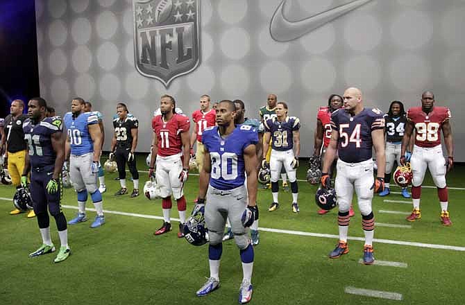 NFL players stand in their new uniforms during a presentation in New York, Tuesday, April 3, 2012. The league and Nike showed off the new look in grand style with a gridiron-styled fashion show at a Brooklyn film studio. 
