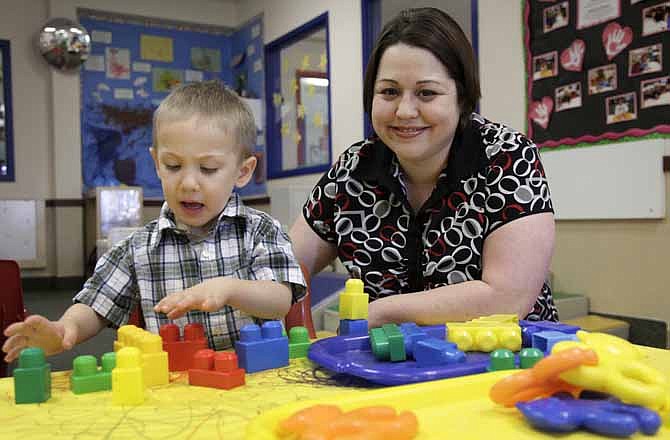 In this April 4, 2012, photo, Kelly Andrus plays with her son Bradley, in his classroom at Children's Choice Learning Centers Inc., in Lewisville, Texas. Bradley, who turns three in a couple of weeks, was diagnosed a year ago with mild autism. For the first time in nearly two decades, experts want to rewrite the definition of autism. Some parents fear that if it's narrowed and their kids lose the label, they may also lose out on special therapist. 
