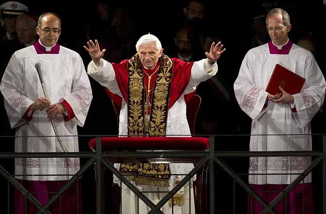 Pope Benedict XVI, center, delivers his blessing at the end of the Via Crucis (Way of the Cross) procession on Good Friday in Rome, Friday, April 6, 2012. The evening Via Crucis procession at the ancient amphitheater is a Rome tradition that draws a large crowd of faithful, including many of the pilgrims who flock to the Italian capital for Holy Week ceremonies before Easter Sunday.