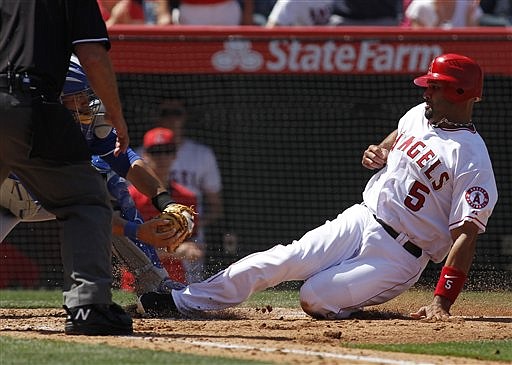 Los Angeles Angels' Albert Pujols, right, slides at home as Kansas City Royals catcher Humberto Quintero moves to take him out on a single by Kendrys Morales during the fourth inning of a baseball game on Saturday, April 7, 2012, in Anaheim, Calif. 