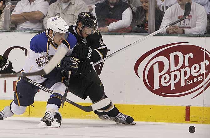 Dallas Stars defenseman Alex Goligoski (33) and St. Louis Blues left wing David Perron (57) battle for control of the puck during the second period of an NHL Hockey game, Saturday, April 7, 2012, in Dallas.