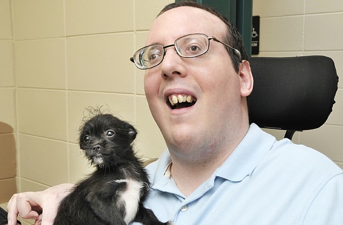 Greg Rackers pets a puppy at the Jefferson City Animal Shelter. Rackers, who volunteers every other week at the shelter, is there to pet the cats and kittens, and if there are no feline animals, he'll play with the dogs.
