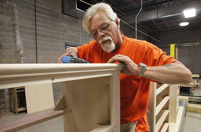 In this Friday, March 16, 2012 photo, Tony Rickman installs moulding on wooden chests in the assembly line area at the Lincolnton Furniture Company in Lincolnton, N.C. Five generations of Cochranes had been furniture makers, but by the mid-1990s the trade was moving to China, land of cheap labor. But earlier this year, Bruce Cochrane reopened with a work force of about 55, part of a small but growing trend called "reshoring." 