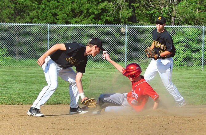 Brad MacLaughlin of the Calvary-Tolton Lions beats the tag attempt at second base of Ryan Loethen of St. Elizabeth during Monday's game at Calvary Lutheran Lions Field. Ethan Oligschlaeger of St. Elizabeth looks on.