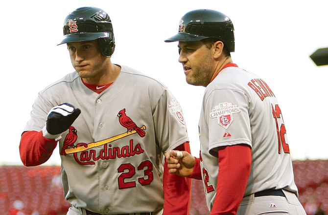 David Freese is congratulated by Cardinal teammate Lance Berkman after hitting a two-run home run in the first inning of Monday's game against the Reds in Cincinnati.