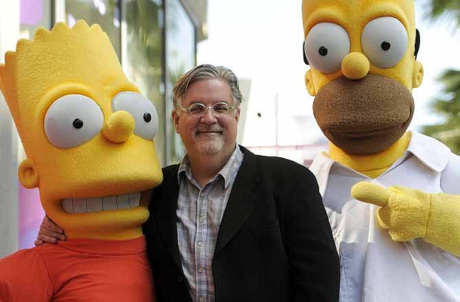 In this Feb. 14, 2012 file photo, Matt Groening, creator of the animated series "The Simpsons," poses with his character creations Bart Simpson, left, and Homer Simpson after he received a star on the Hollywood Walk of Fame in Los Angeles. One of the best-kept secrets in television history has been revealed, with Groening pointing to Springfield, Ore. as the inspiration for the animated hometown of Homer and family. 