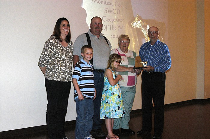 Carl Allee presents the SWCD 2011 Cooperator of the Year award to Sherry Cox and family. The Cox family pictured all live on the family farm. Front row, from left, Sherry's grandchildren Jac and Briar Cox; back row, Jo and husband Joey Cox, Sherry's son, Sherry and Allee.  