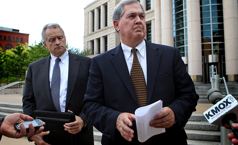 Former Missouri Gov. Roger Wilson, right, reads a statement acknowledging his mistake in front of the Eagleton Courthouse after he pleaded guilty to misusing money involved in an illegal campaign donation.