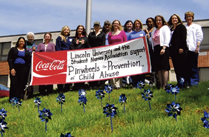 Members of Lincoln University Student Nurses Association, faculty and staff pose with the 100 pinwheels they sold and placed in front of Eliff Hall in recognition of child abuse prevention. The pinwheels will remain in place through today.