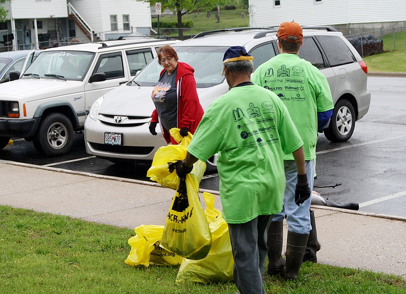 Volunteers from the Optimists Club and Girl Scout Troop 70293 gather up their haul of trash on Fulton Pride Day. The two clubs teamed up to clean the park near Westminster College, where they went above and beyond the call of duty and fished trash out of the lake with sticks.