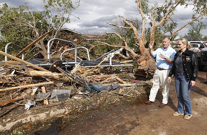 Oklahoma Gov. Mary Fallin, right, and John Doak, left, Oklahoma Insurance Commissioner, tour a tornado damaged neighborhood Sunday in Woodward, Okla.