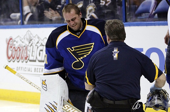 Blues goaltender Jaroslav Halak is tended to by trainer Ray Barile after he collided with teammate Barret Jackman during Saturday night's game against the Sharks in St. Louis.