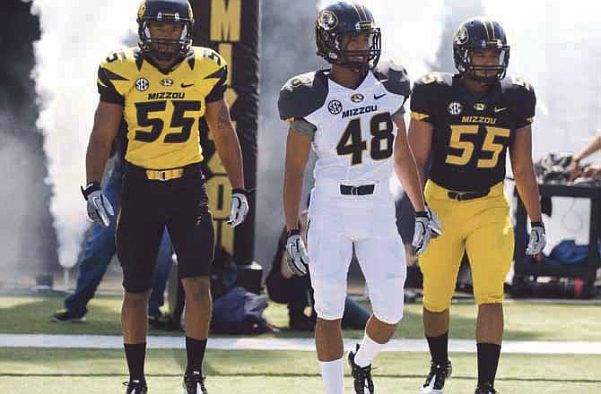Players model the new design for the Missouri football uniforms Saturday afternoon as they enter Faurot Field during halftime of the Black and Gold Game.