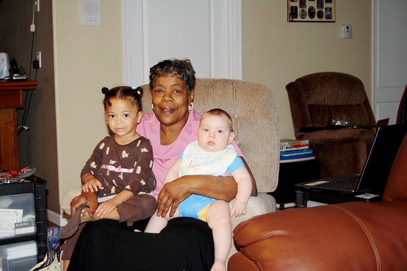 Grandma Kemp holds two of the children she watches, Mira Joy Garrett, 2, and baby Bryson, 6 months. Kemp has watched more than 75 children in her 20 years providing daycare services in Fulton.