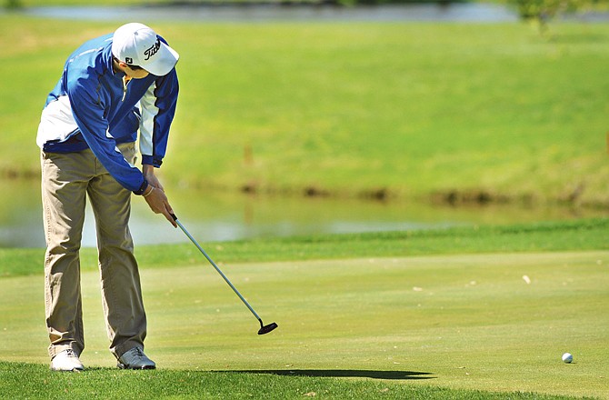 Michael Kehoe of Helias rolls a putt on the fifth hole Monday in the Helias Invitational at Meadow Lake Acres Country Club.