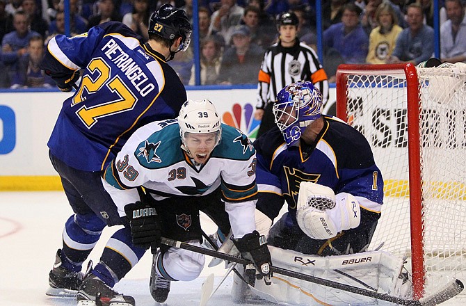 The Blues' Alexander Steen (right) reaches for a loose puck as Sharks goalie Antti Niemi and Brent Burns defend during the second period of the Western Conference quarterfinals Saturday in St. Louis.