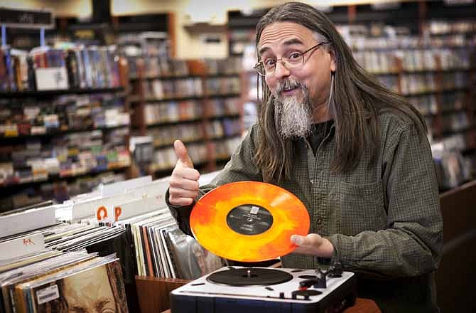 Chris Bown poses Thursday, April 19, 2012, in Scarborough, Maine, with a copy of The Knack's "Live in Los Angeles 1978." The vinyl record is being released for Record Store Day on Saturday, April 21. Brown, the head of marketing for Bull Moose Music, conceived of the day five years ago. This year there'll be more than 300 new and special releases. 