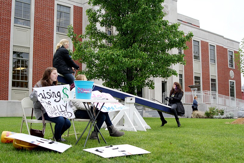 Delta Gamma members Brandon Hofherr and Erin Kennedy seesaw while fellow sisters Allie Malone and Meghan Greenwalt collect donations for Seesaw for Sight. The sorority raises donations for visually impaired people every year by seesawing in front of the courthouse.
