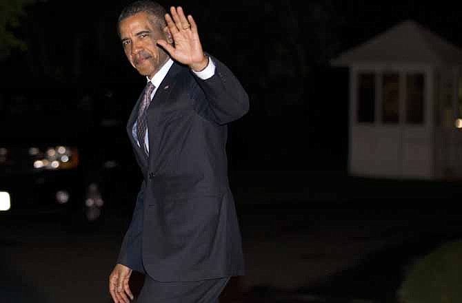 President Barack Obama waves as he arrives on the South Lawn of the White House on Wednesday, April 18, 2012, in Washington. 