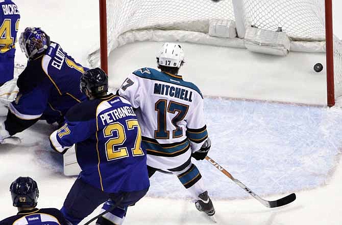 San Jose Sharks' Torrey Mitchell (17) watches as a shot by teammate Joe Thornton (not shown) slips past St. Louis Blues goalie Brian Elliott, top left, and Alex Pietrangelo (27) during the second period in Game 5 of an NHL first-round playoff series hockey game on Saturday, April 21, 2012, in St. Louis.