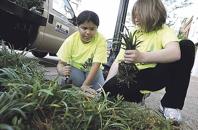 Girl Scout Cienna O'Donnell, 10, left, and Brianna Caton, 9, plant flowers as part of the SERVE Jeff City event Saturday morning on High Street. More than 300 volunteers helped out at 11 project sites. 