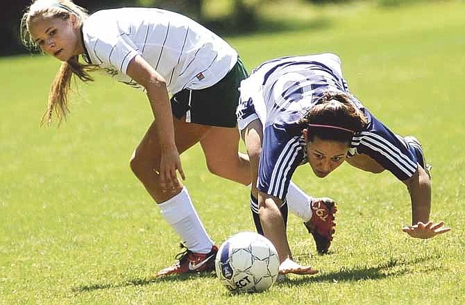 Helias forward Lexi Melcher (right) tripped up while battling for a ball with Springfield Catholic's Anna Skrade during Saturday's Capital City Soccer Invitational at the 179 Soccer Park.