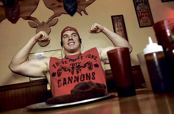 Professional eater and bodybuilder Randy Santel raises his hands in victory after becoming the first person to complete the "Mega Moose Challenge" at Moose Brothers BBQ in Jefferson City on Saturday.