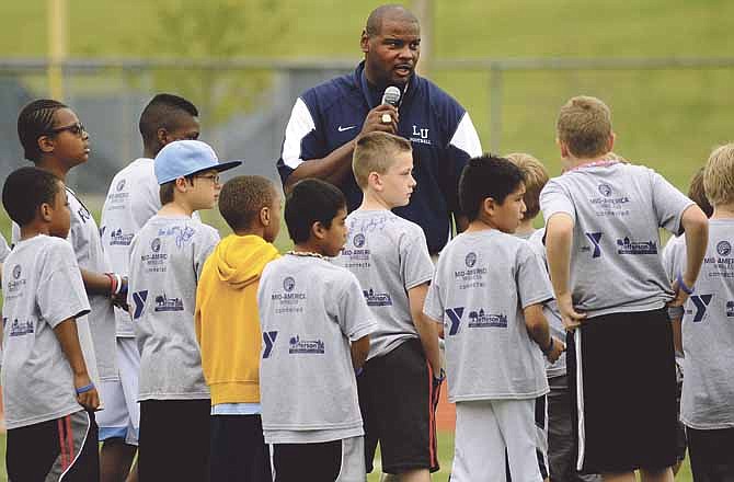 Lincoln head coach Mike Jones speaks to a group of football campers just before the start of the Blue Tigers' annual spring game at Dwight T. Reed Stadium on Saturday.