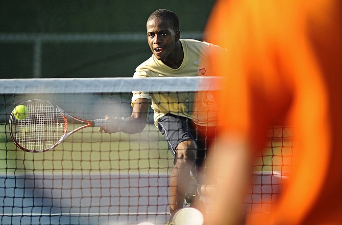 Helias's J.J. Charles lunges for a return while competing in a doubles match with Nick Kroeger against Waynesville on Tuesday at Washington Park.