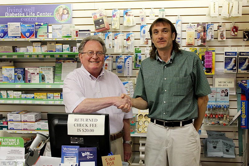 Al Real, left, welcomes Mark Jennings to Saults Drug Store. Jennings, formerly an employee at Red Cross Pharmacy, is buying into Saults and will assume partial ownership.