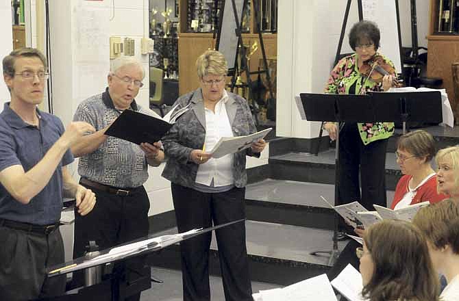 Members of the Jefferson City Cantorum practice last week ahead of their performance Saturday under director Glen Webb, left. The group will perform songs from favorite movies and plays.