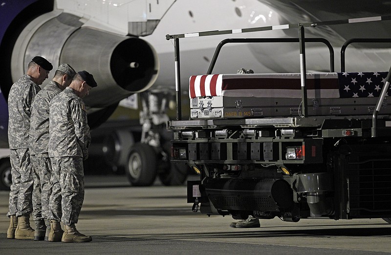 Chaplain Col. Dennis Goodwin, left, directs a prayer Thursday over the remains of Army Capt. Bruce K. Clark at Dover Air Force Base, Del. 